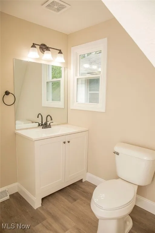 Half bath featuring wood finished floors and vanity
