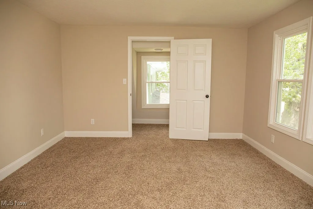 Unfurnished room featuring healthy amount of natural light and light colored carpet