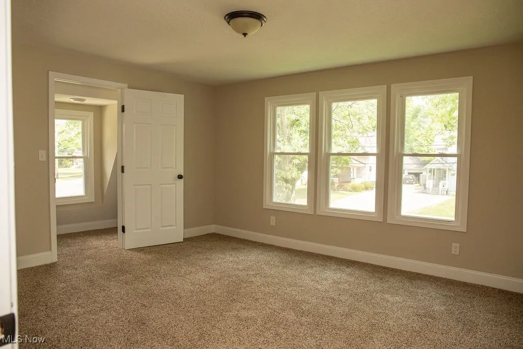 Carpeted empty room with baseboards