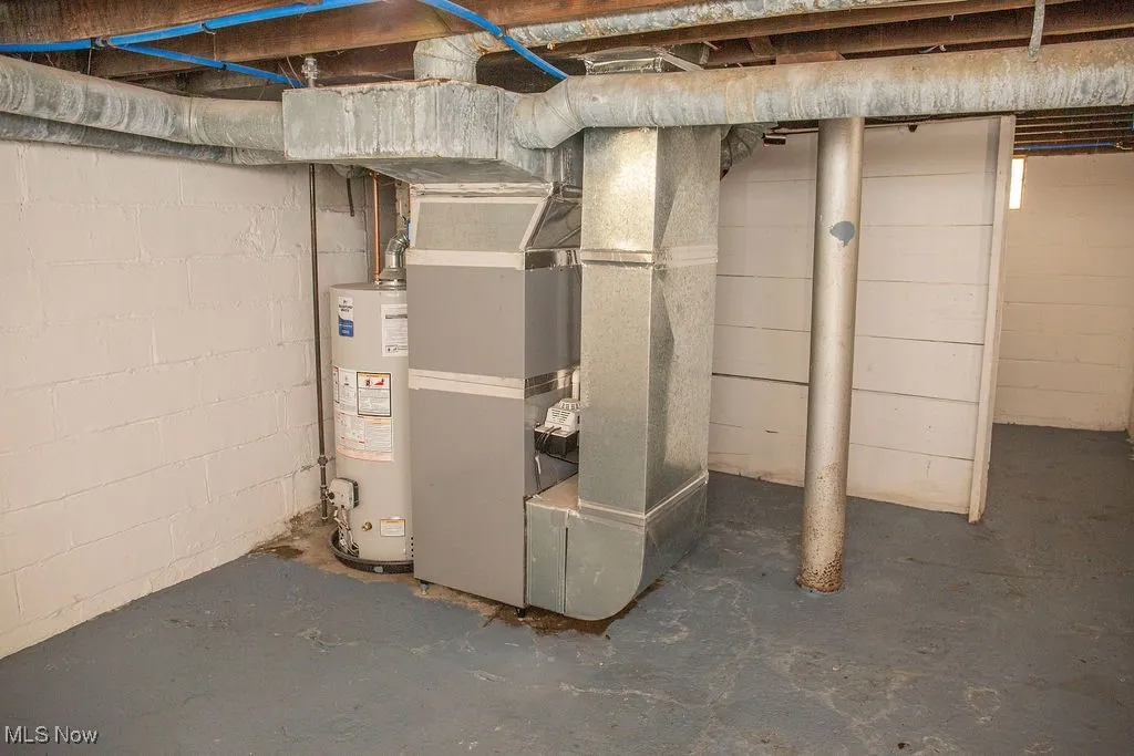 Unfinished basement featuring gas water heater and heating unit