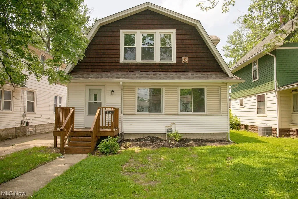 Dutch colonial with a gambrel roof, a front lawn, and roof with shingles