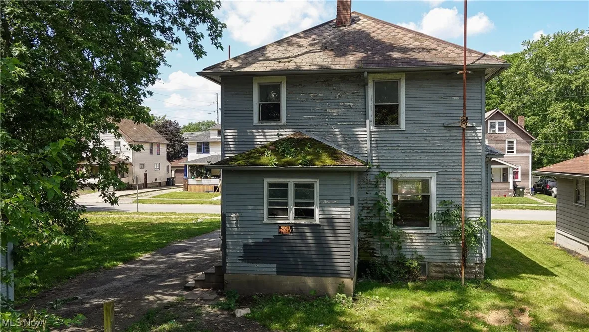 Rear view of house with a lawn and a chimney
