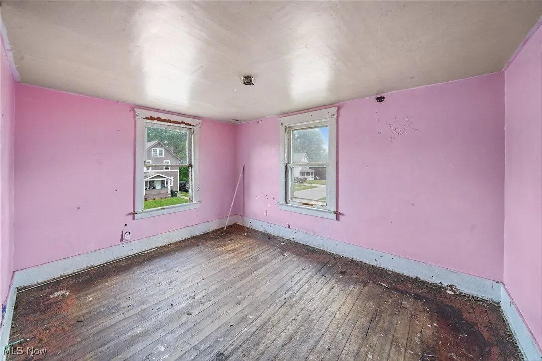 Empty room with hardwood / wood-style floors and baseboards