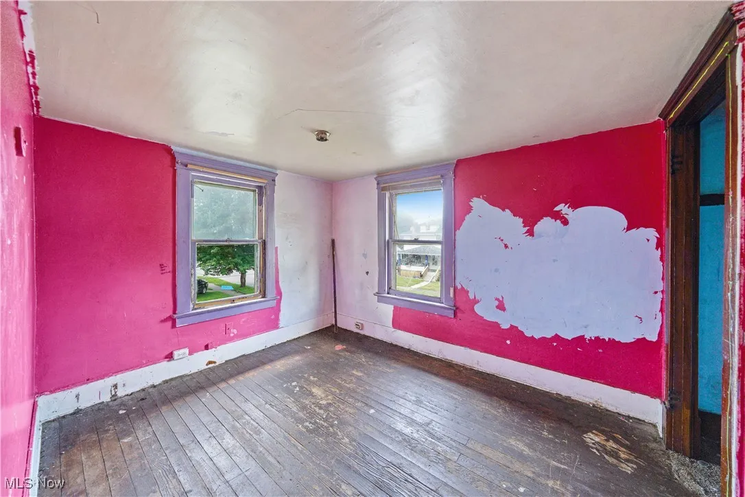 Empty room featuring wood-type flooring and baseboards