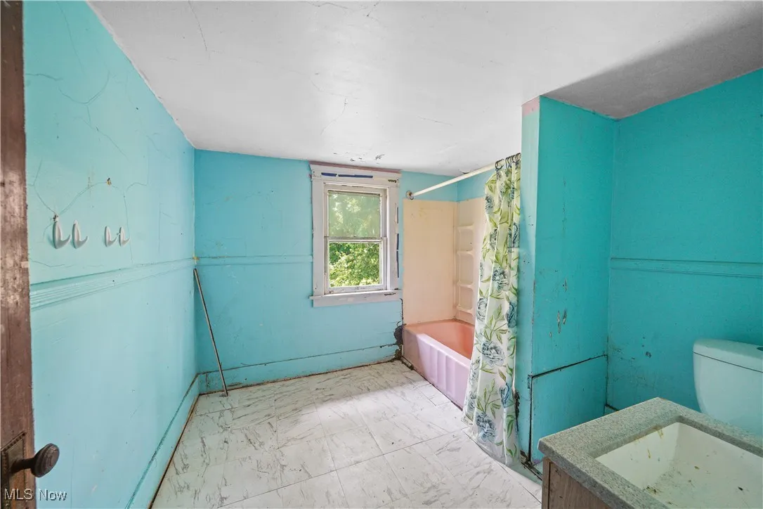 Bathroom with shower / bath combo with shower curtain and vanity
