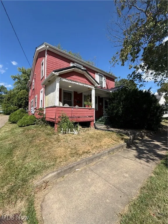 View of front of property featuring covered porch and a front lawn
