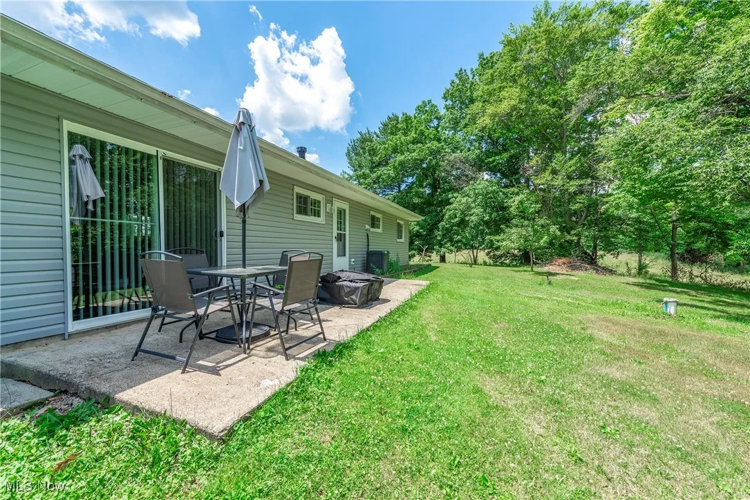 View of grassy yard featuring a patio area