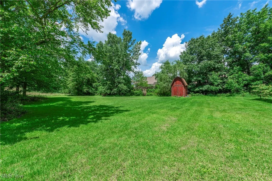 View of grassy yard featuring an outbuilding and a barn