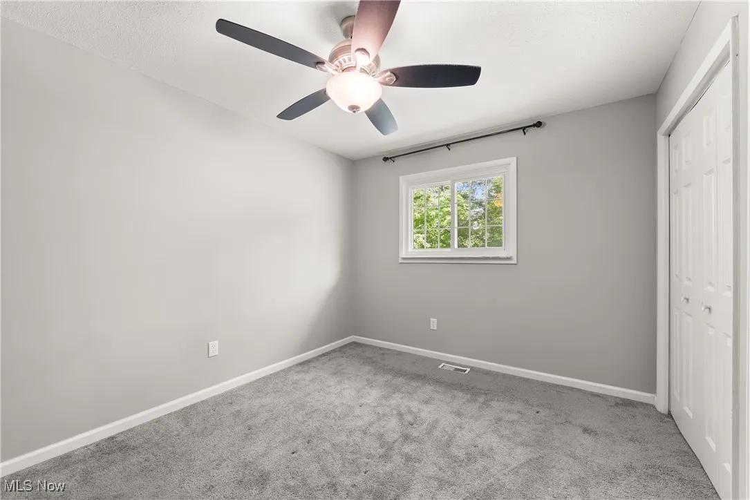 Unfurnished bedroom featuring a closet, carpet flooring, and ceiling fan