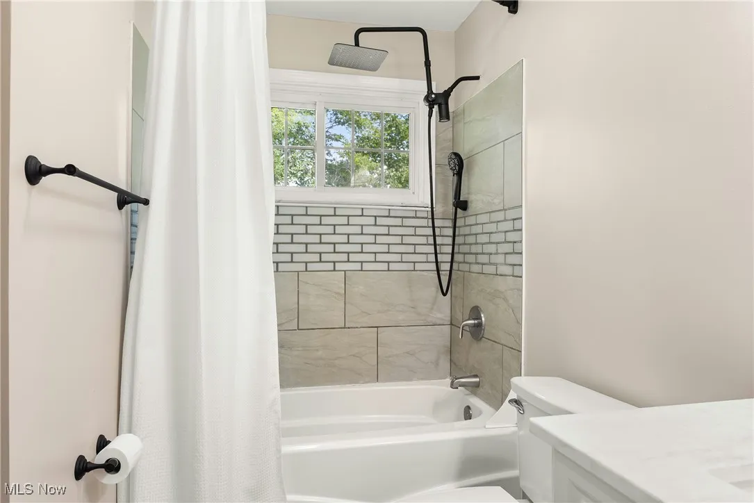 Full bath featuring shower / tub combo and vanity