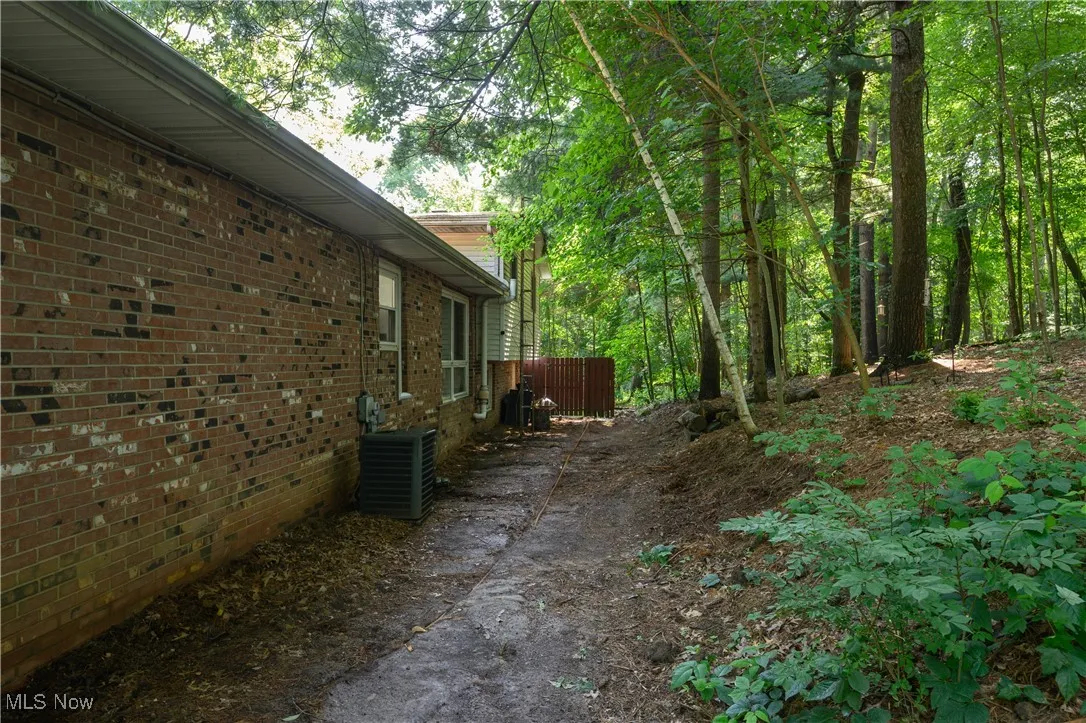 View of home's exterior featuring a central AC unit and brick siding