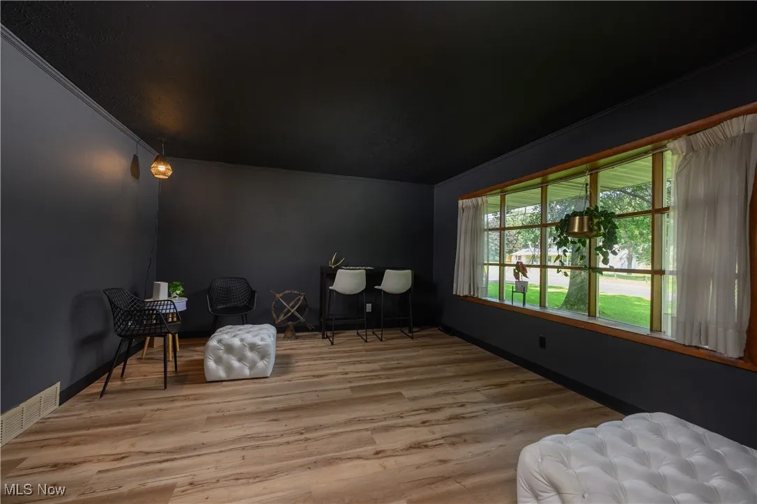 Sitting room featuring wood finished floors and crown molding