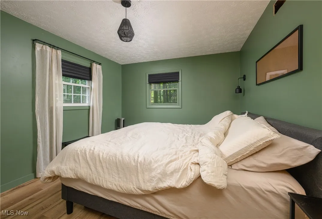 Bedroom featuring wood finished floors and a textured ceiling