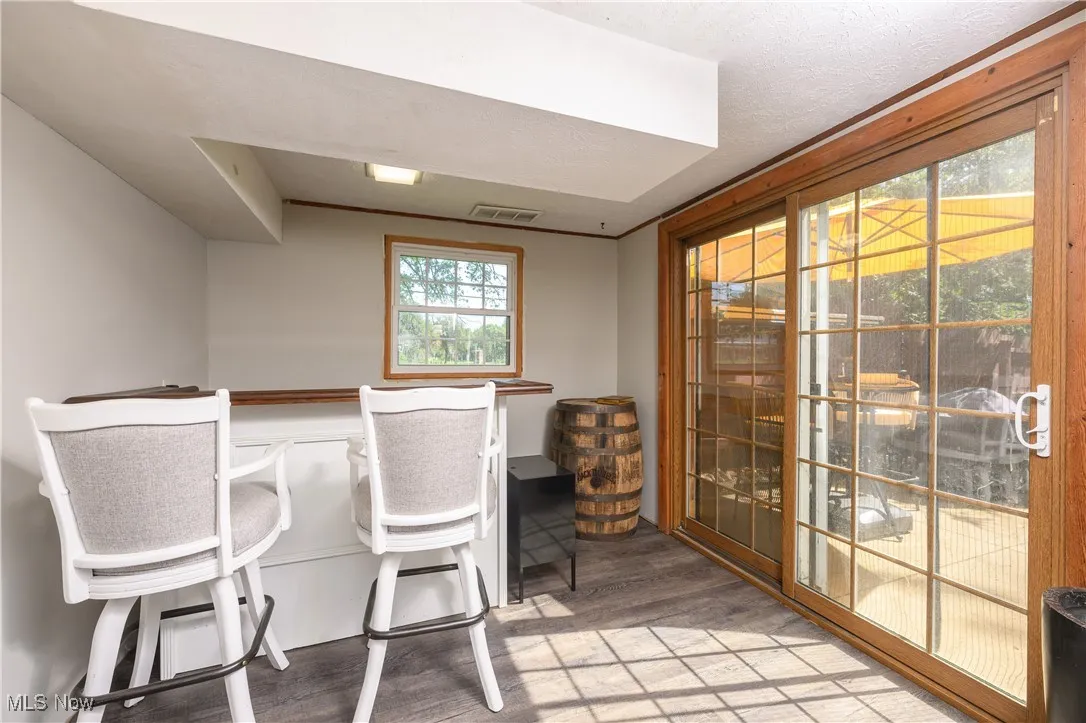 Dining space with wood finished floors and a bar