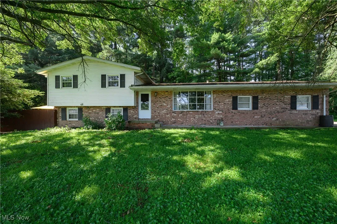Tri-level home featuring brick siding and a front lawn