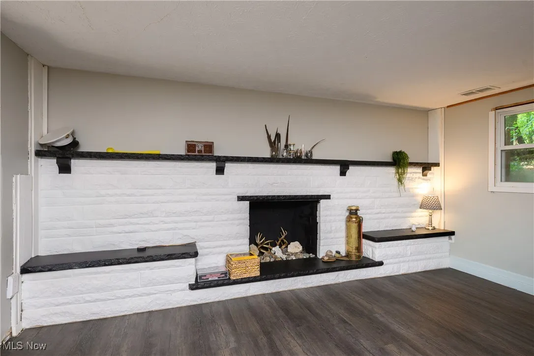Unfurnished living room with wood finished floors and a fireplace