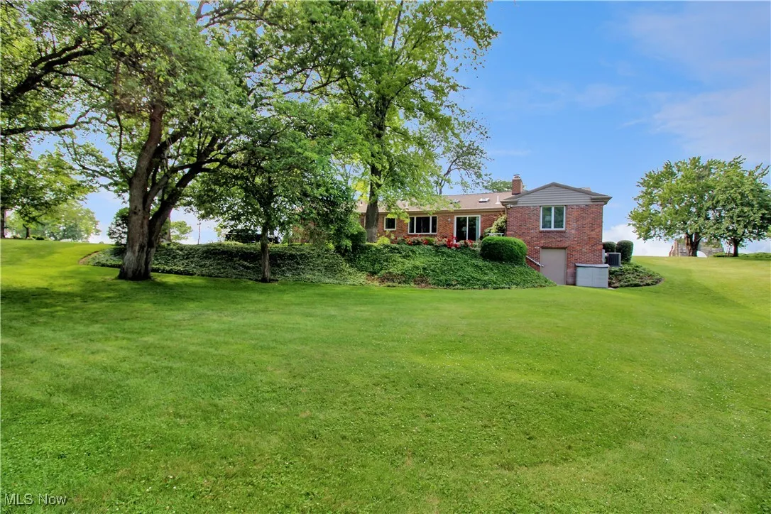 View of grassy yard featuring a garage