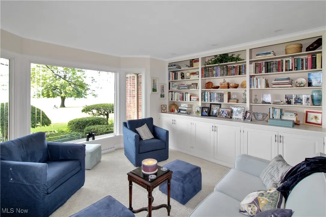 Living room with light carpet and ornamental molding