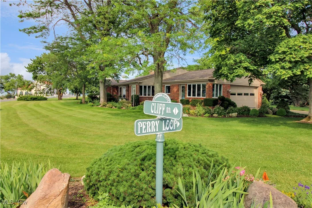 Ranch-style home featuring an attached garage, a front yard, and brick siding