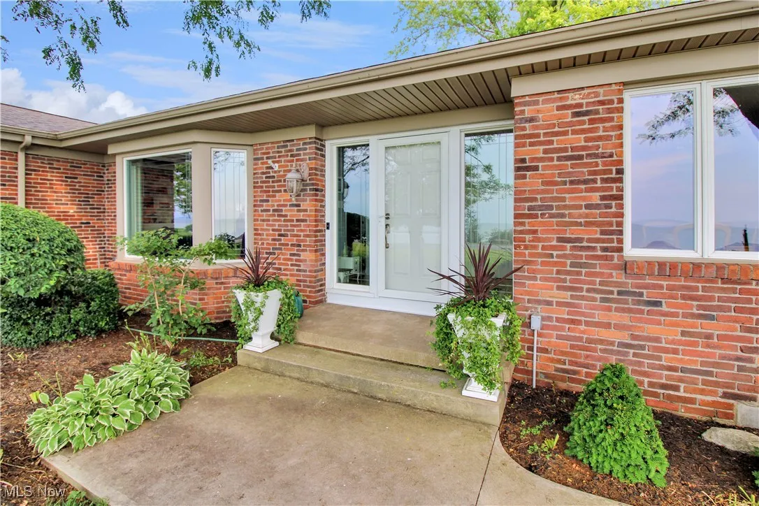 View of exterior entry featuring brick siding