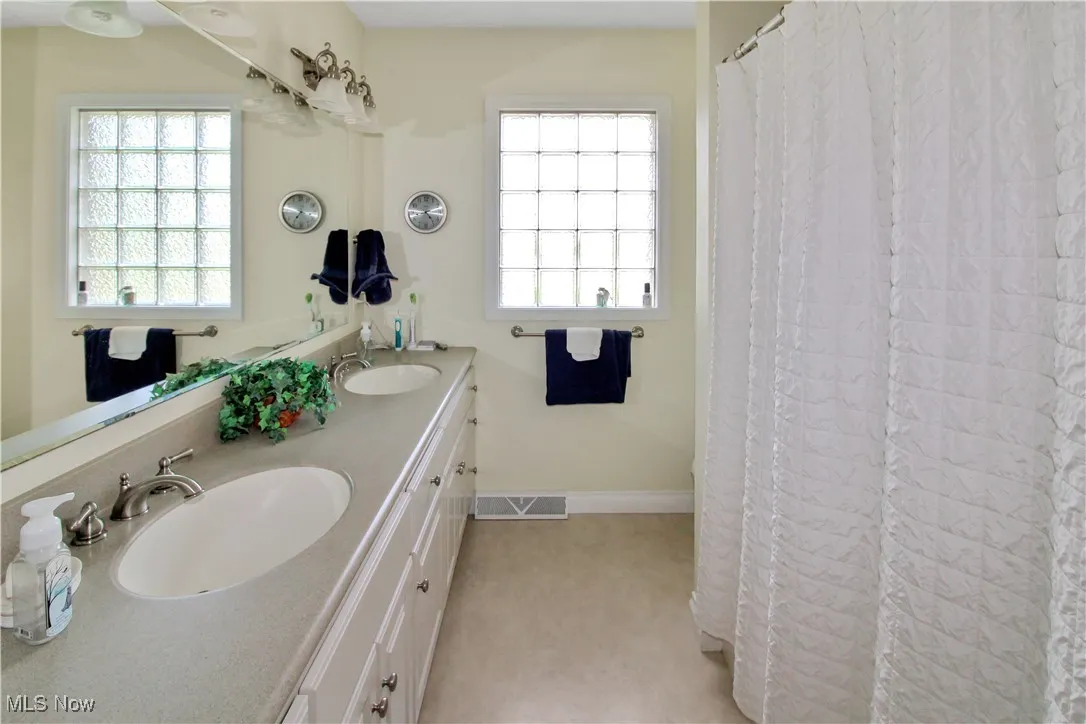 Bathroom featuring double vanity and healthy amount of natural light