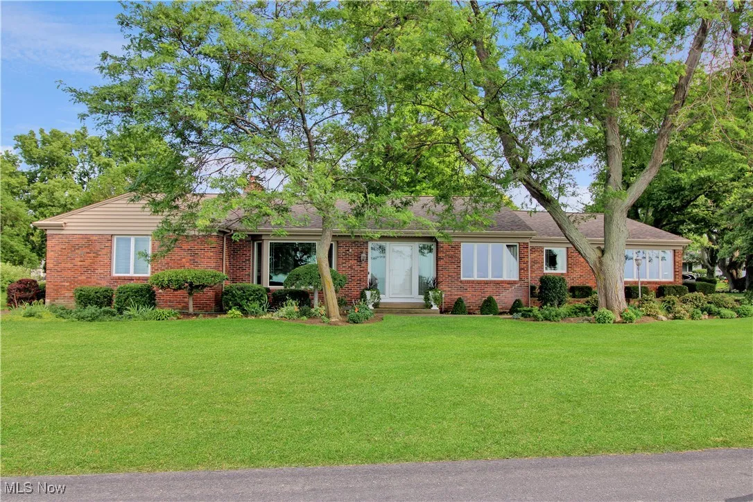 Single story home with brick siding and a front yard