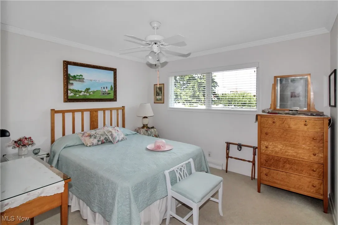 Carpeted bedroom featuring crown molding