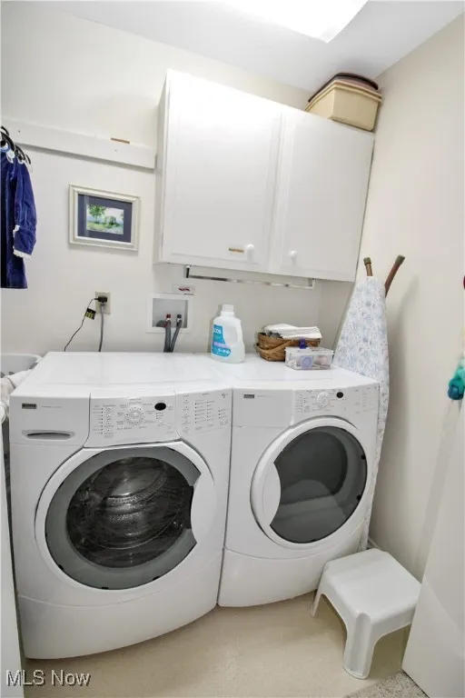 Laundry room featuring cabinet space and independent washer and dryer
