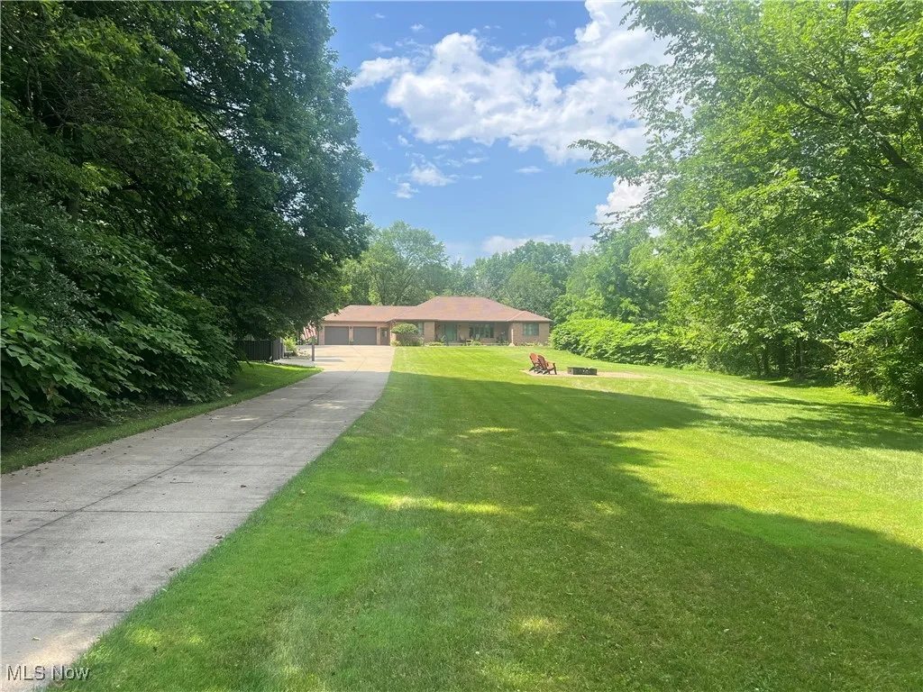 Ranch-style house featuring a front lawn and driveway