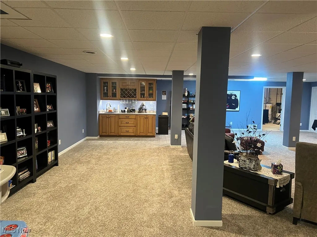 Indoor wet bar with light colored carpet, a drop ceiling, and recessed lighting