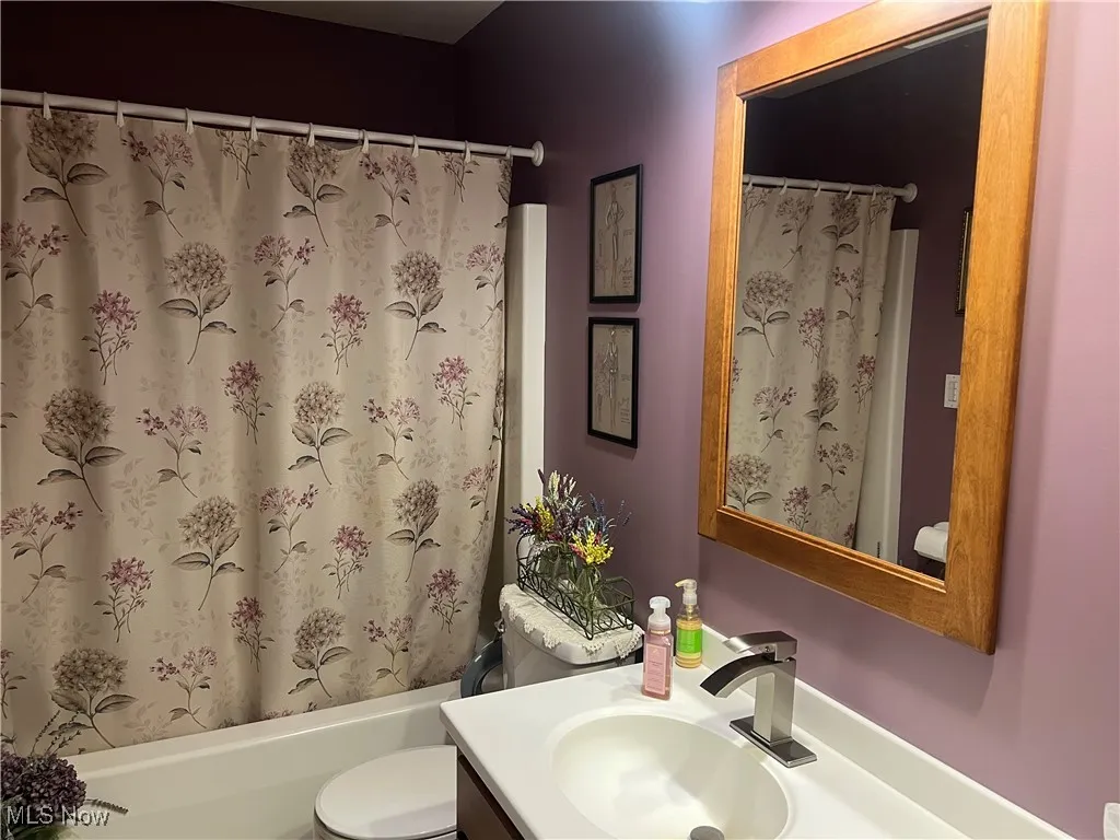 Bathroom with vanity and shower / bathtub combination with curtain