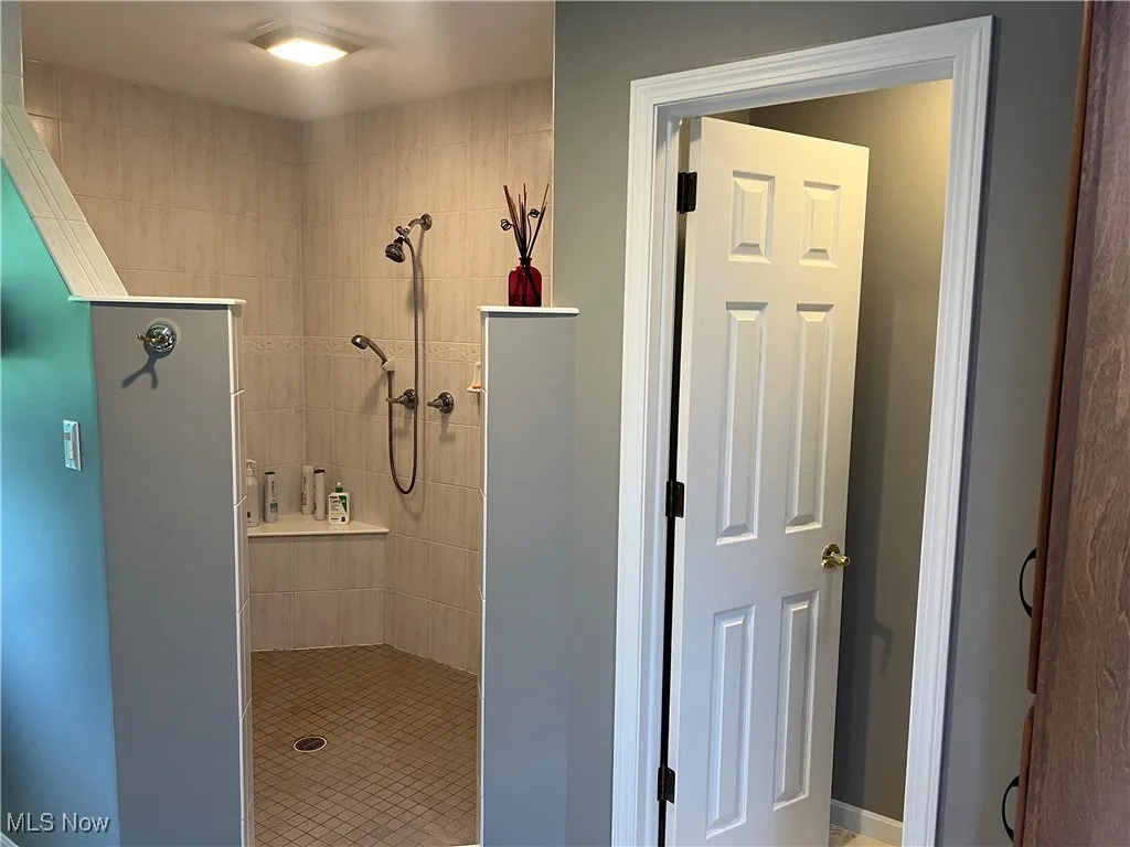Full bath featuring tiled shower