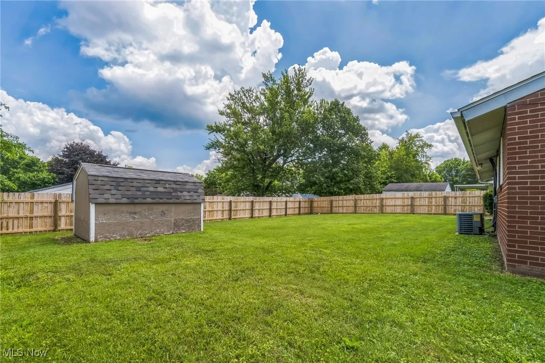 Fenced backyard with a storage shed