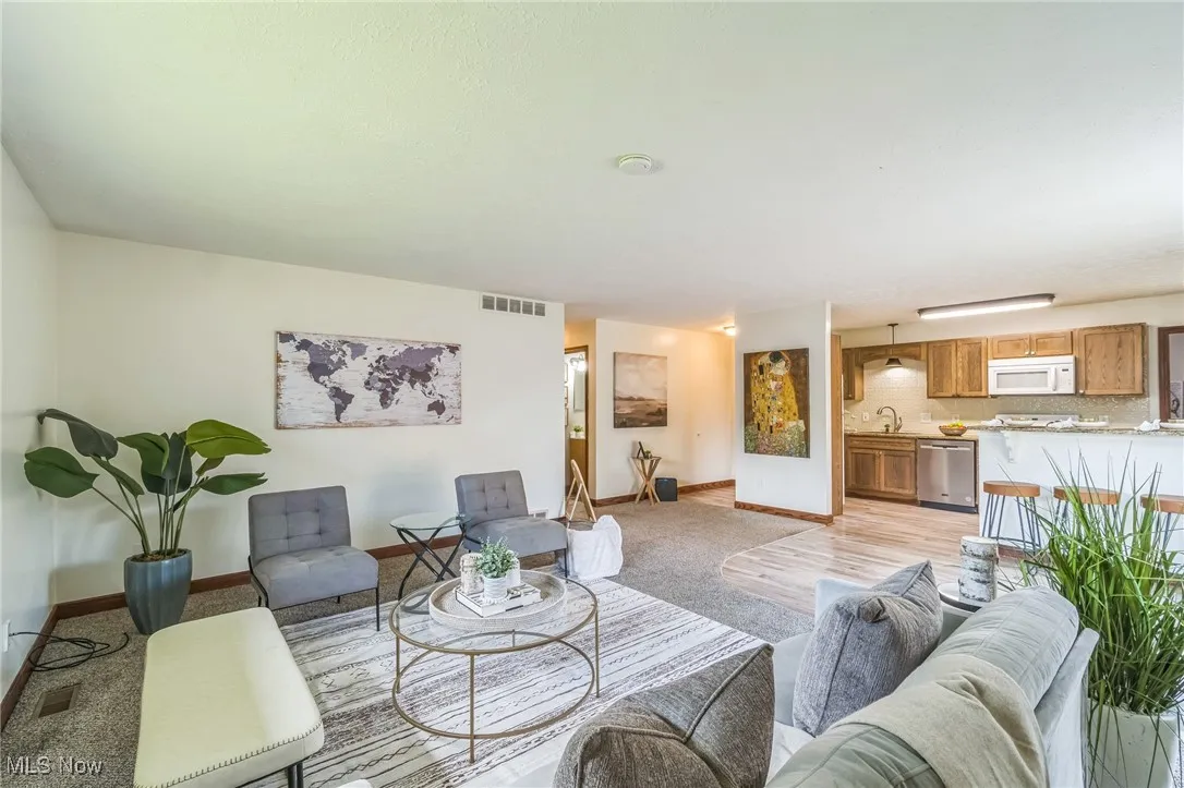 Living room featuring light colored carpet and baseboards