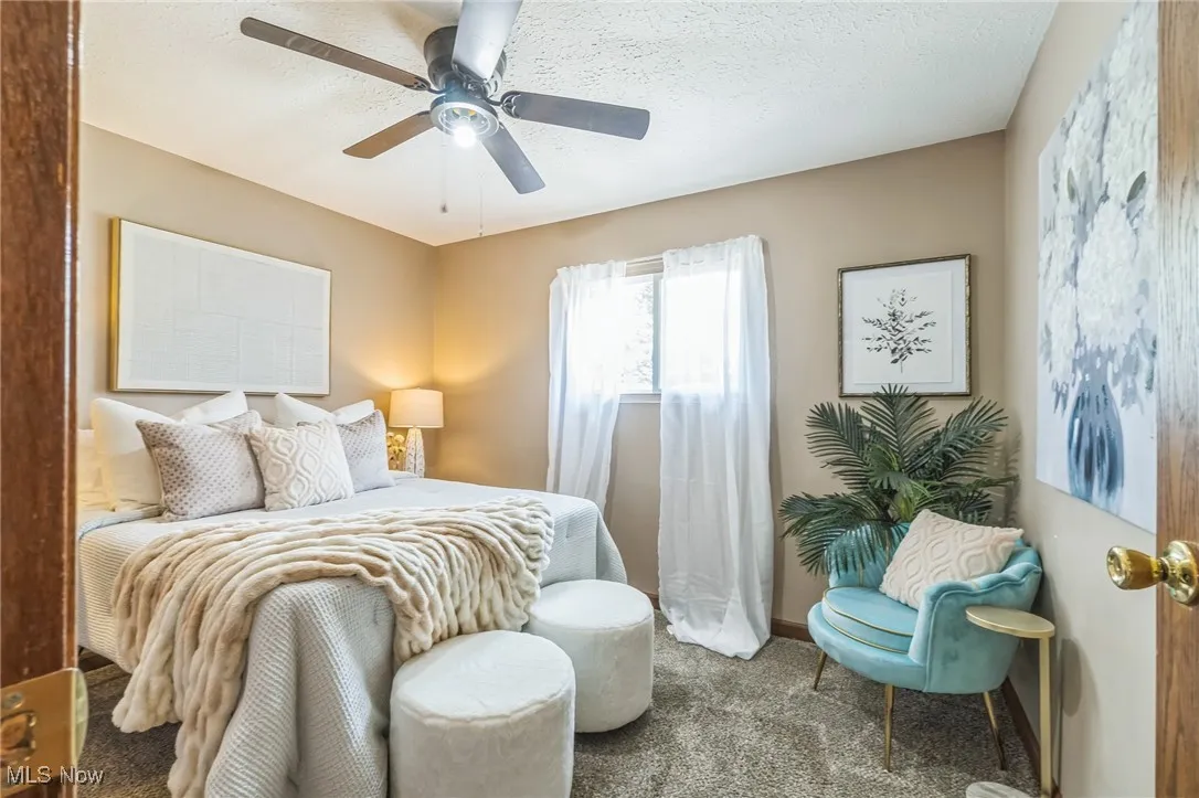 Carpeted bedroom featuring a ceiling fan and baseboards