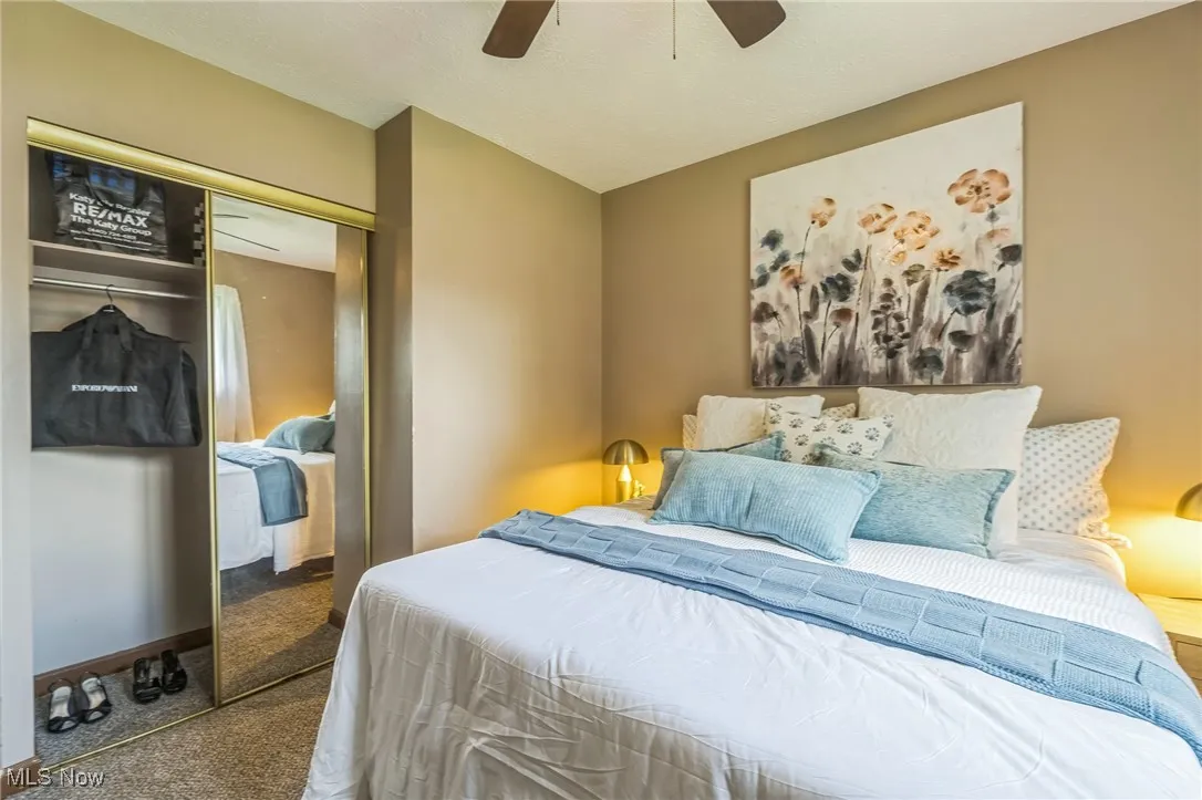 Carpeted bedroom with a closet and ceiling fan