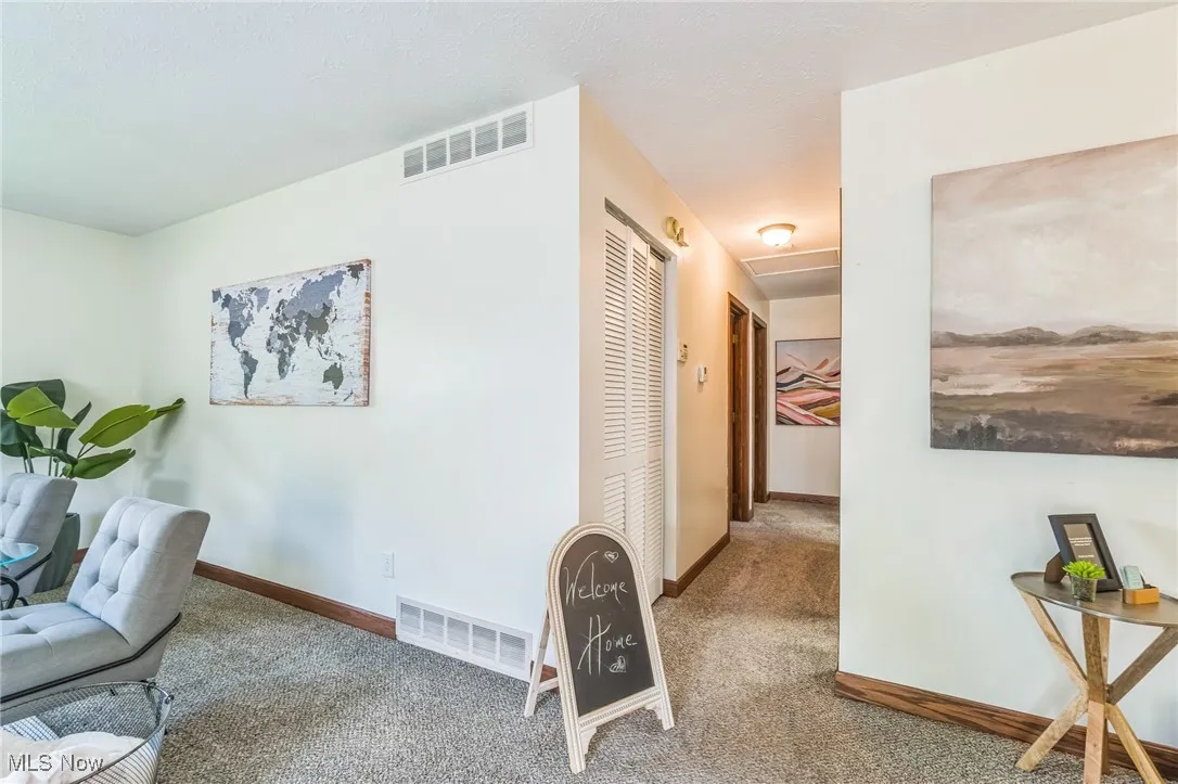 Corridor with carpet floors and attic access