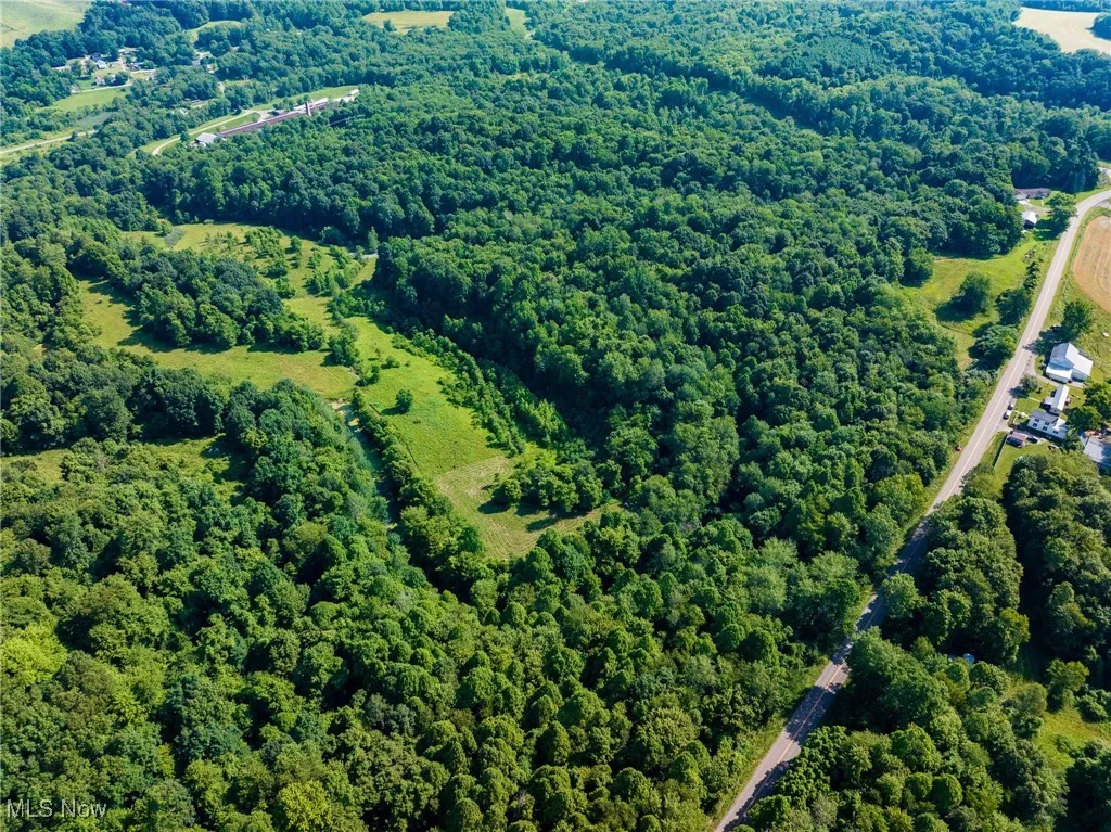 Aerial view of property's location with a heavily wooded area