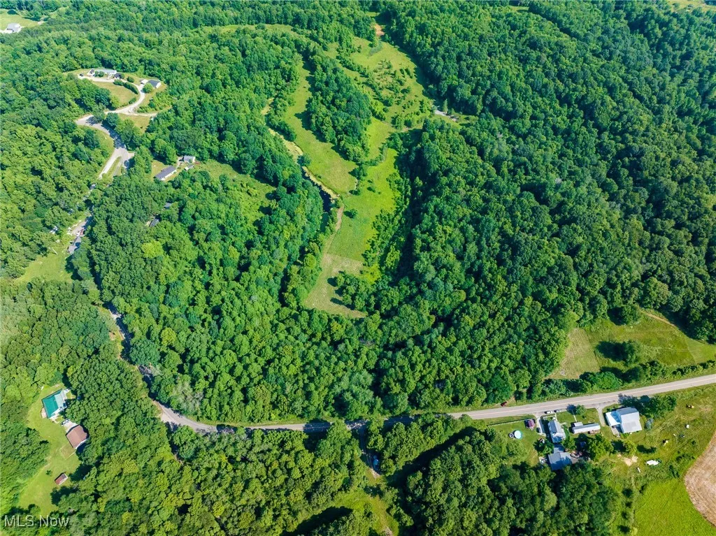 Aerial view of property and surrounding area featuring a heavily wooded area