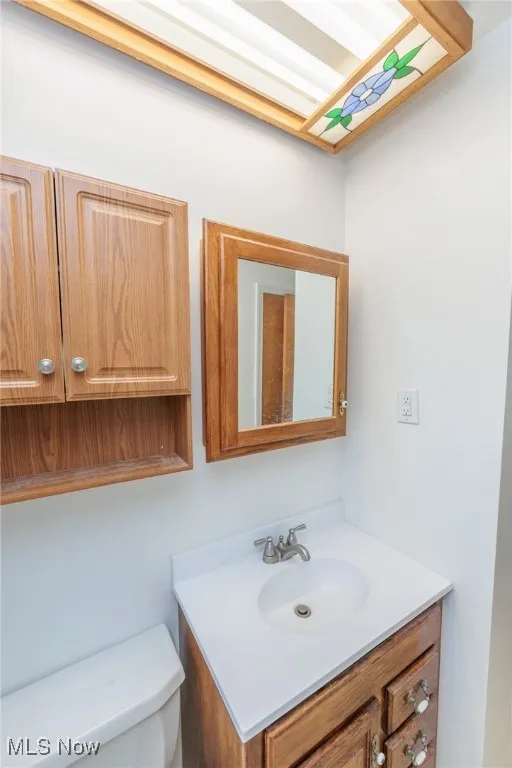 Half bathroom with vanity and toilet
