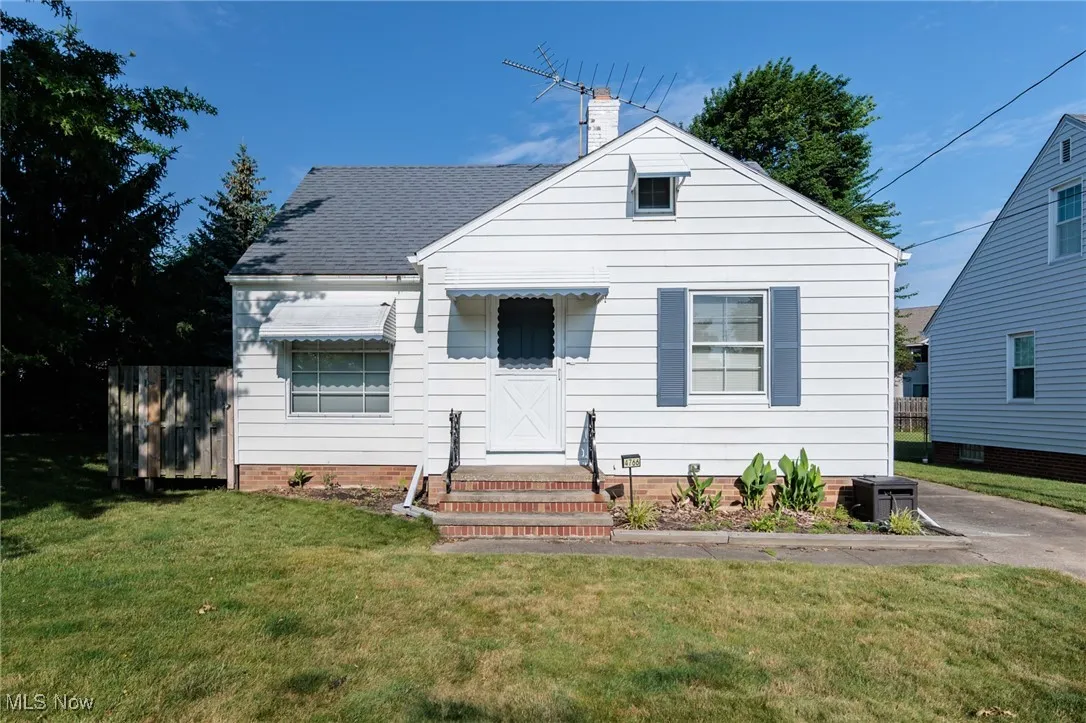 Bungalow with a front lawn, a chimney, and roof with shingles
