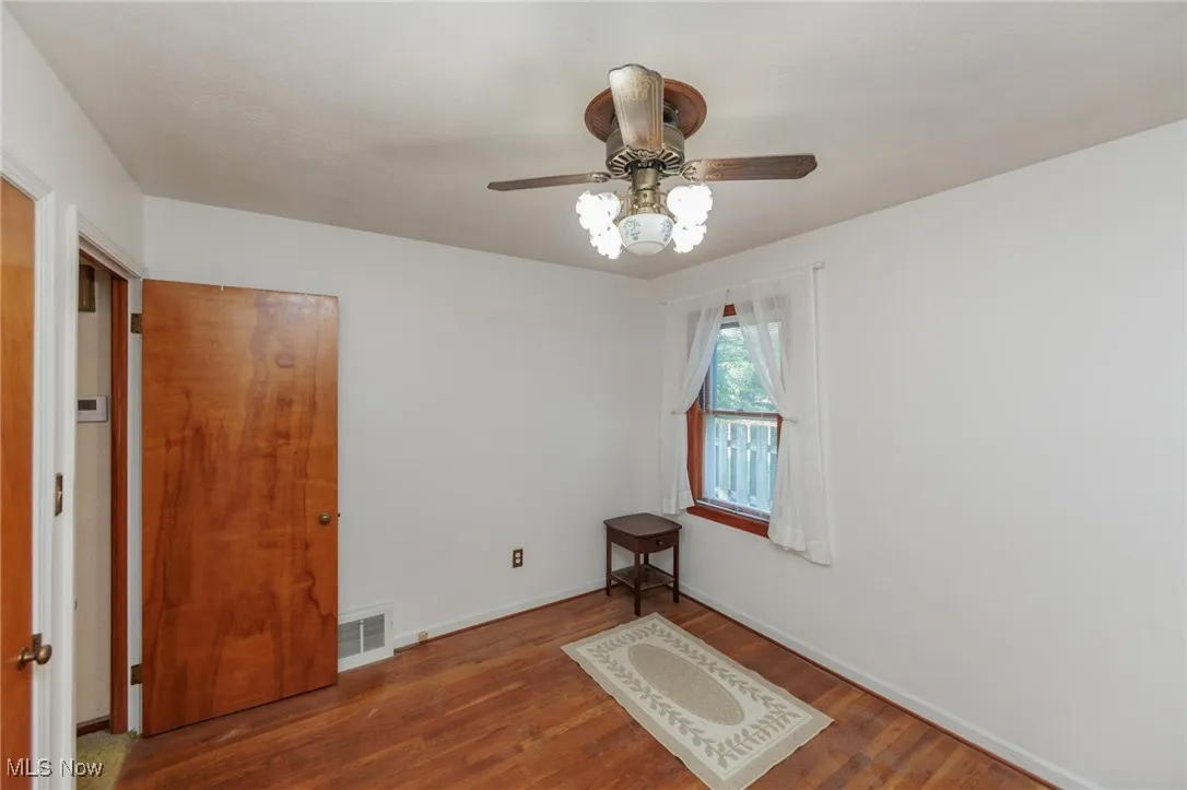 Unfurnished room with wood finished floors and a ceiling fan