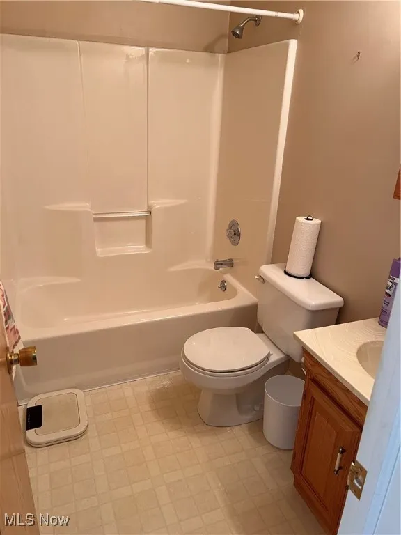 Bathroom with vanity, tile patterned floors, and bathtub / shower combination