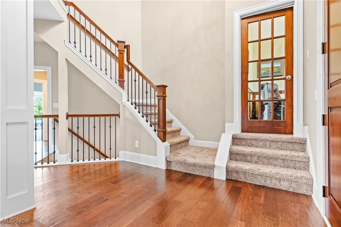 Staircase with wood finished floors and baseboards