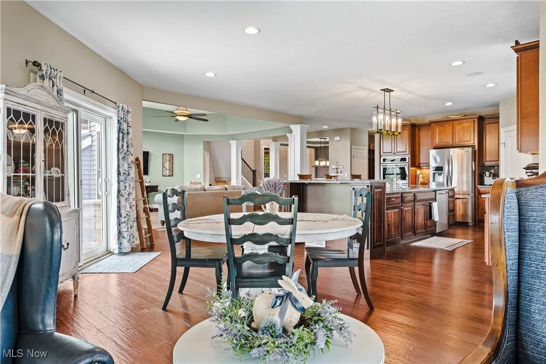 Dining space featuring dark wood-style flooring, plenty of natural light, recessed lighting, ceiling fan, and a chandelier