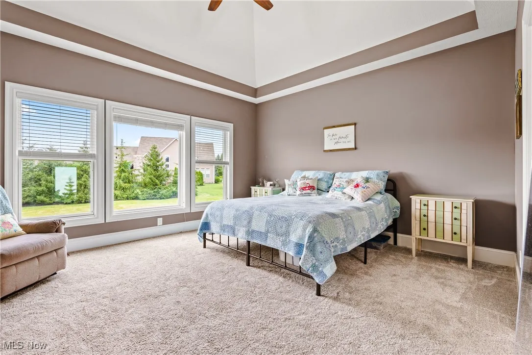 Carpeted bedroom featuring ceiling fan and baseboards