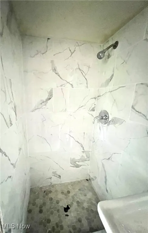 Bathroom featuring a marble finish shower