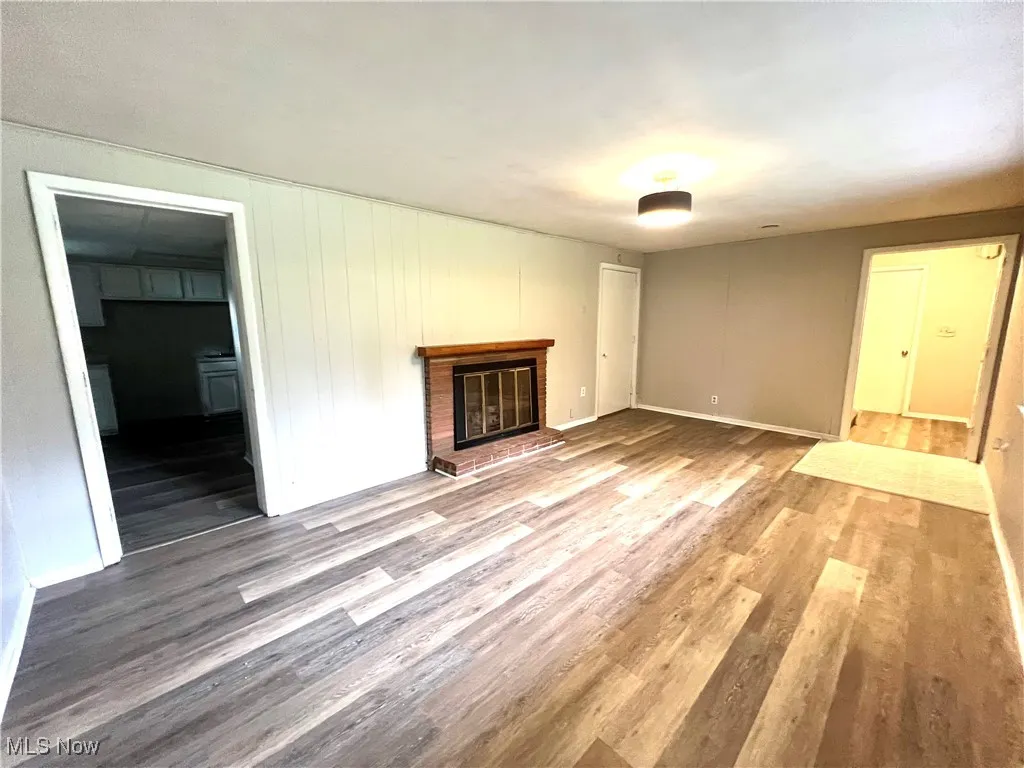 Unfurnished living room with wood finished floors and a fireplace