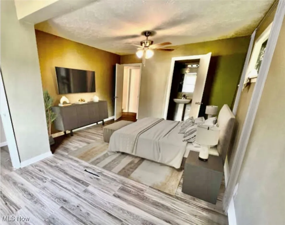 Bedroom with wood finished floors, a textured ceiling, and a ceiling fan
