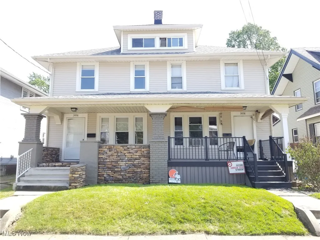 Traditional style home with a porch, a front yard, and a shingled roof